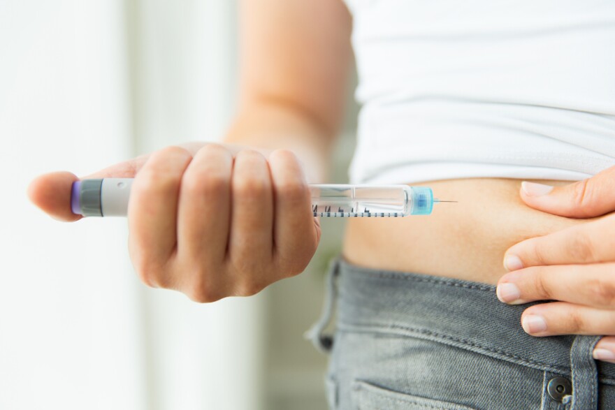 Close-up of a woman's hands making injection with insulin pen or syringe