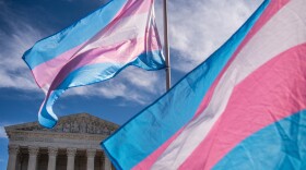 Two transgender pride flags waving in front of the Supreme Court.