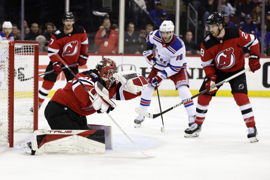 New Jersey Devils goaltender Akira Schmid, front left, makes a save in front of New York Rangers right wing Patrick Kane (88) during the third period of Game 7 of an NHL hockey Stanley Cup first-round playoff series Monday, May 1, 2023, in Newark, N.J