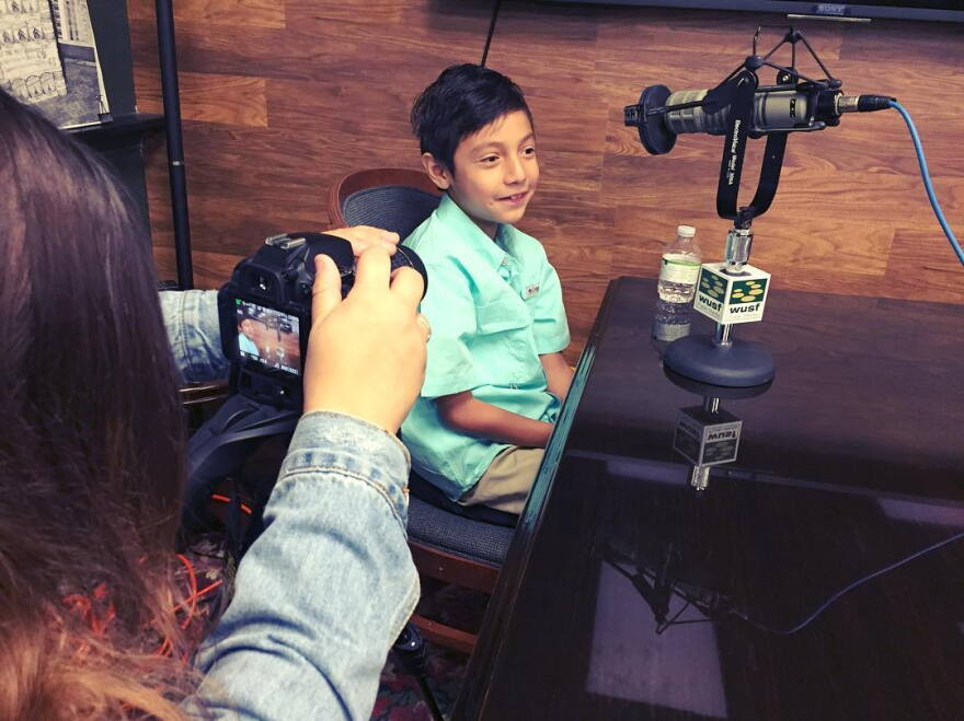 Junior Archivist Jaden Felix is interviewed while USF student journalist Yara Zayas takes his picture.