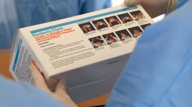 Touro University Nevada medical students check a box of N95 respirators and surgical masks before conducting medical screenings at a temporary homeless shelter. (Ethan Miller/Getty Images)