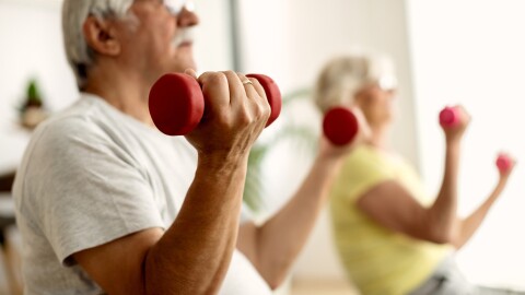 Older adults lift small red weights