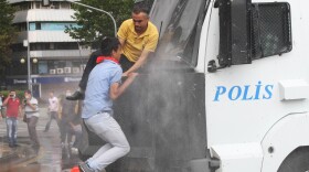 Protesters climb onto a police truck mounted with a water cannon during clashes with riot police at a demonstration in Ankara on Sunday.