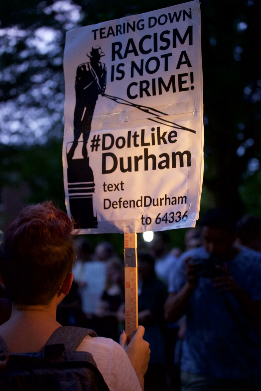 A demonstrator carries a #DoItLikeDurham sign in Polk Place on August 20th, 2018. Hours later the confederate monument 'Silent Sam' would come down.