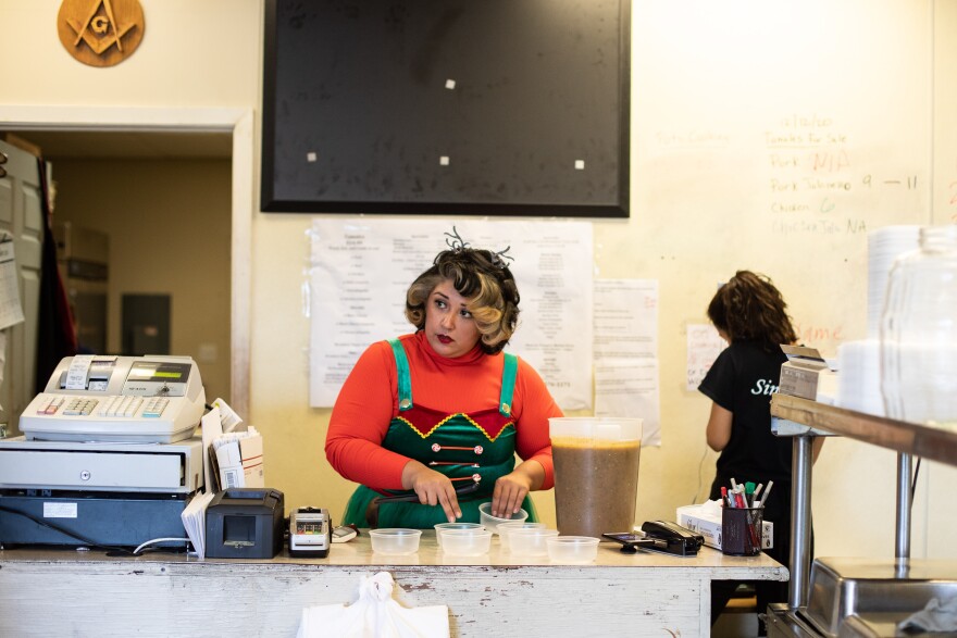 Lena Leal, scoops salsa into plastic containers before curbside orders pile up. 