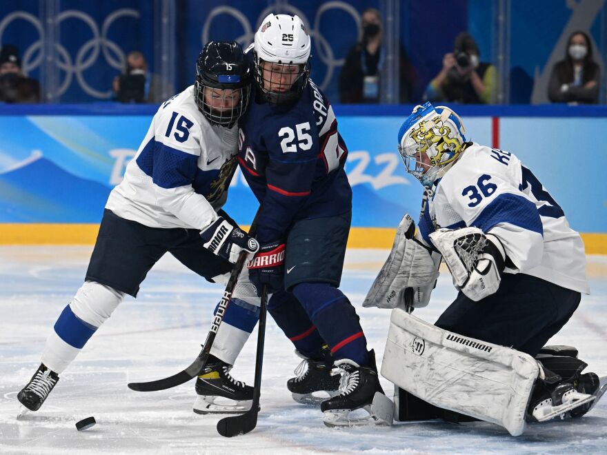 Finland's Minnamari Tuominen (left) and Team USA's Alexandra Carpenter vie for the puck next to Finland's goaltender Anni Keisala during the women's ice hockey semi-final match of the Beijing 2022 Winter Olympic Games. [Kirill Kudryavtsev  / AFP via Getty Images]