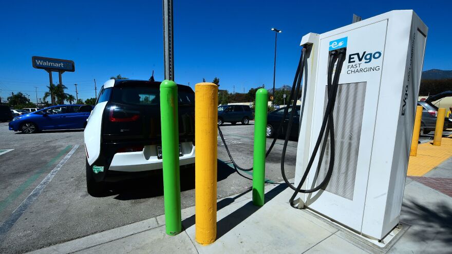 An electric vehicle is plugged in for a charge at stations in a Walmart parking lot in Duarte, Calif. 