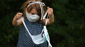 A child plays with a face mask.