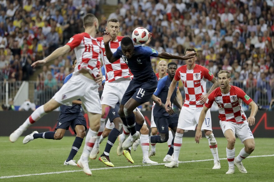 Croatia's Ivan Perisic, second left, handles the ball to give away a penalty as he jumps for the ball with France's Blaise Matuidi during the final match between France and Croatia.
