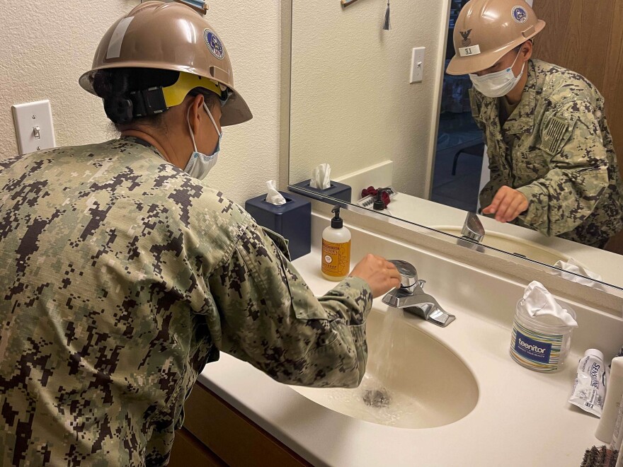 JOINT BASE PEARL HARBOR-HICKAM, Hawaiʻi (Dec. 30, 2021) A construction electrician examines a bathroom sink during the home water system flushing restoration process at Joint Base Pearl Harbor-Hickam housing communities. (U.S. Navy)