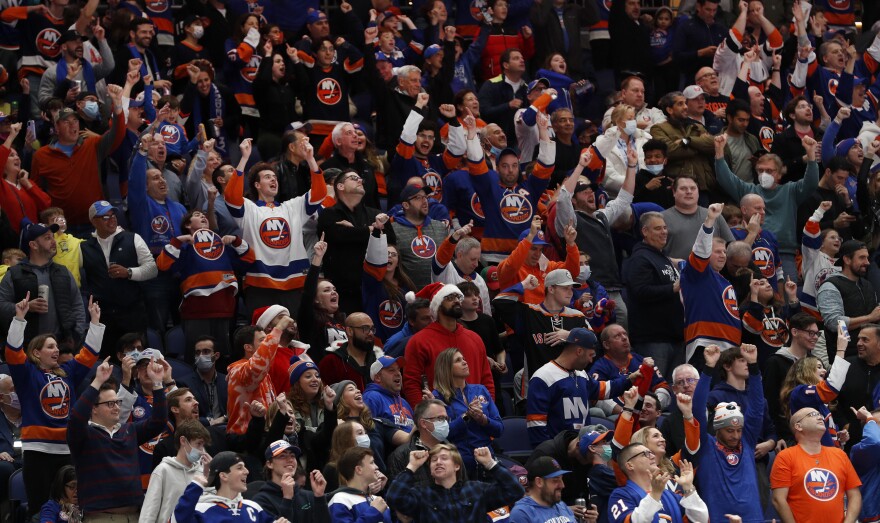 New York Islanders fans cheer a goal against the New Jersey Devils during the second period an NHL hockey game on Saturday, Dec. 11, 2021, in Elmont, N.Y. (AP Photo/Jim McIsaac)