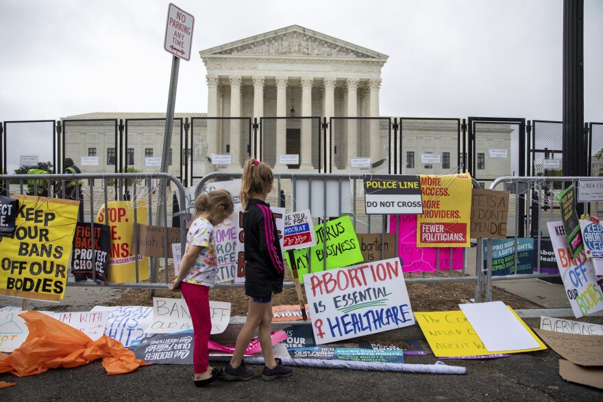 Two girls look at signs during a rally for for abortion rights in front of the Supreme Court of the United States in Washington, Saturday, May 14, 2022, during protests across the country. (AP Photo/Amanda Andrade-Rhoades)