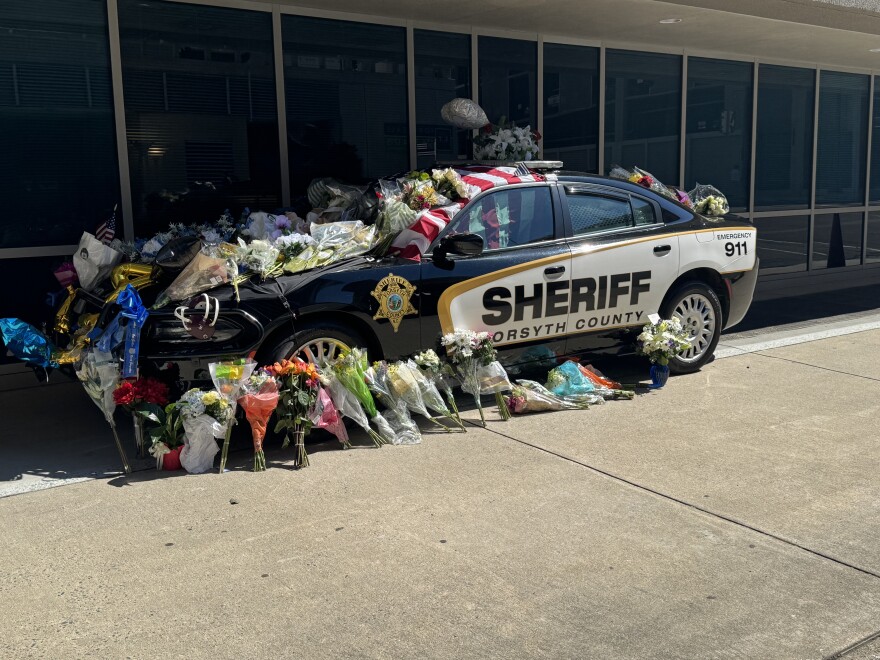 A photo of a Forsyth County Sheriff's vehicle decorated with flowers to honor Deputy Kaleb Mitchell