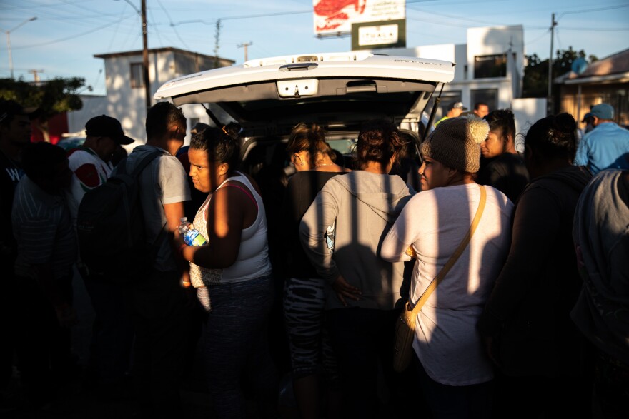 Migrants wait in a line as volunteers donate food in northern Tijuana. With city resources thinly spread, citizens answered the call by offering things like winter clothing and food.