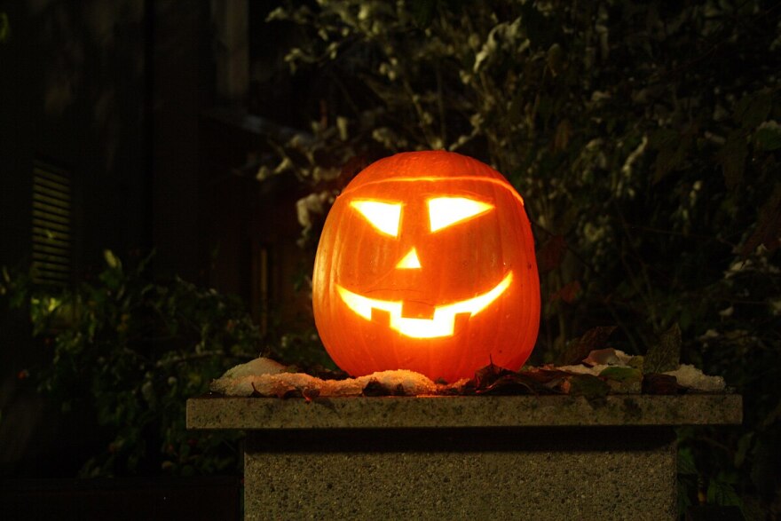 A carved pumpkin sits outside. 