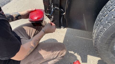 A volunteer works on a malfunctioning taillight during a free clinic held in a Northland church parking lot on July 25. The Kansas City Democratic Socialists of America began staging the events around the area in March as a way to help immigrants avoid a traffic stop, fearful that an encounter could escalate into detention by immigration agents.