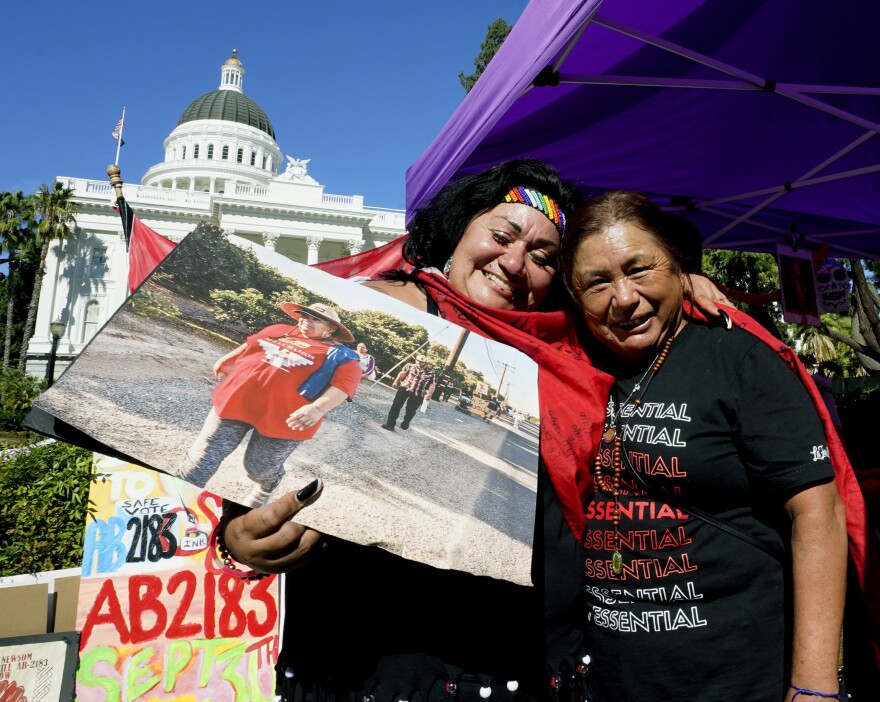 Farmworkers Cynthia Burgos, left and Teresa Maldonado, right, hug after Gov. Gavin Newsom signed a bill aimed at making it easier for farmworkers to unionize in Sacramento, Calif., Wednesday, Sept. 28, 2022. Newsom joined about two dozen farmworkers outside the state Capitol to sign the bill. Both Burgos and Maldonado had joined others in a march from Delano to Sacramento to draw attention to the bill.