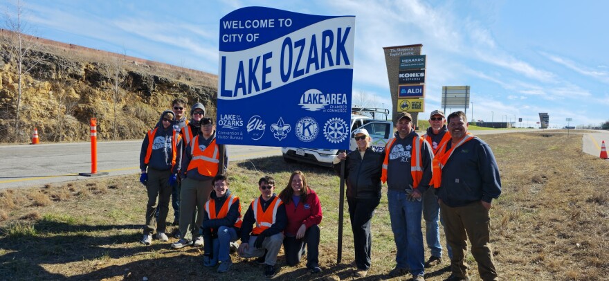Scout John Hayes, 18, kneels next to him mom Amanda after helping to build a new roadway sign that welcomes travelers to the City of Lake Ozark earlier this year.
