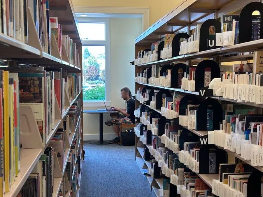 FILE: Blare Stew uses the Belmont Library in Multnomah County last summer. Libraries in some Oregon cities and counties are facing financial cuts that could result in increased stress for librarians.