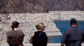 Tourists on the Hoover Dam look out at the bathtub ring of minerals that shows the former water levels of Lake Mead near Boulder City, Nev., on Friday, Aug. 7, 2026.