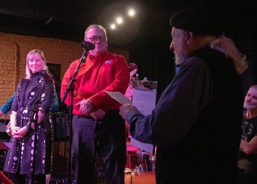 Willow Wetherall, Director of Downtown South Bend, and Tony Krabill, Program Director of WVPE Public Radio, answer questions from George Schricker while playing "Shoot the Moon" during the Wild Rose Moon Radio Hour at Merriman's Playhouse in South Bend.