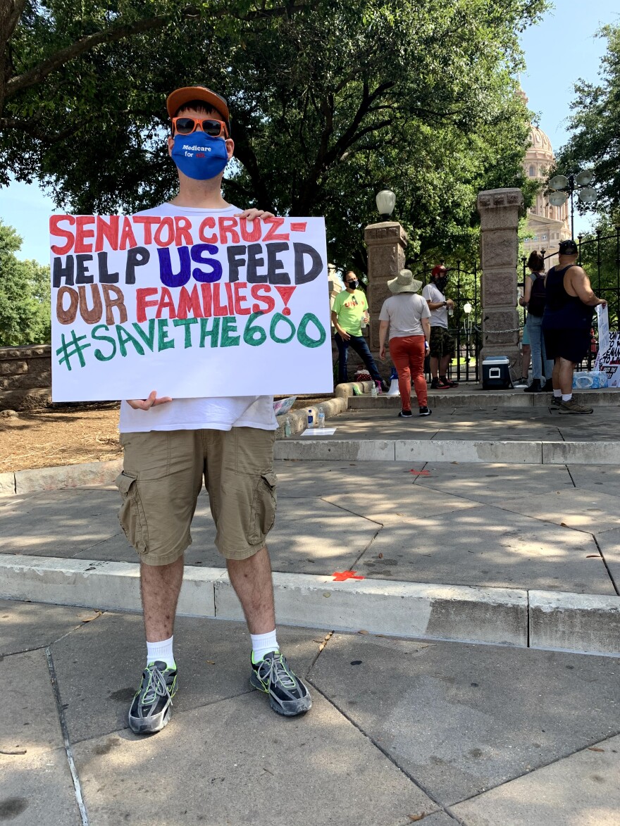 A protester holds a sign near TK.