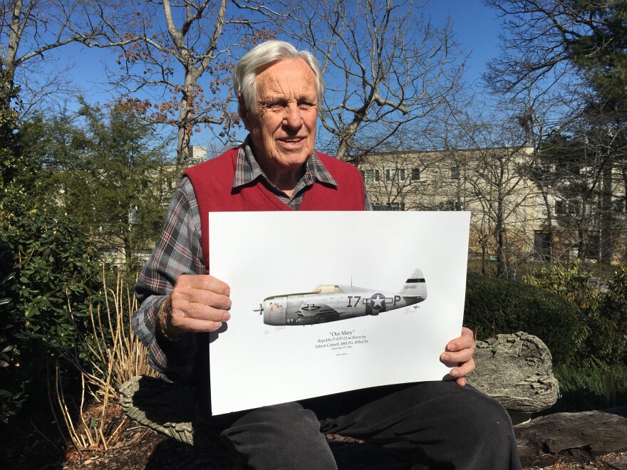 Edwin Cottrell holds an illustration of the P-47D fighter plane he flew in World War II.