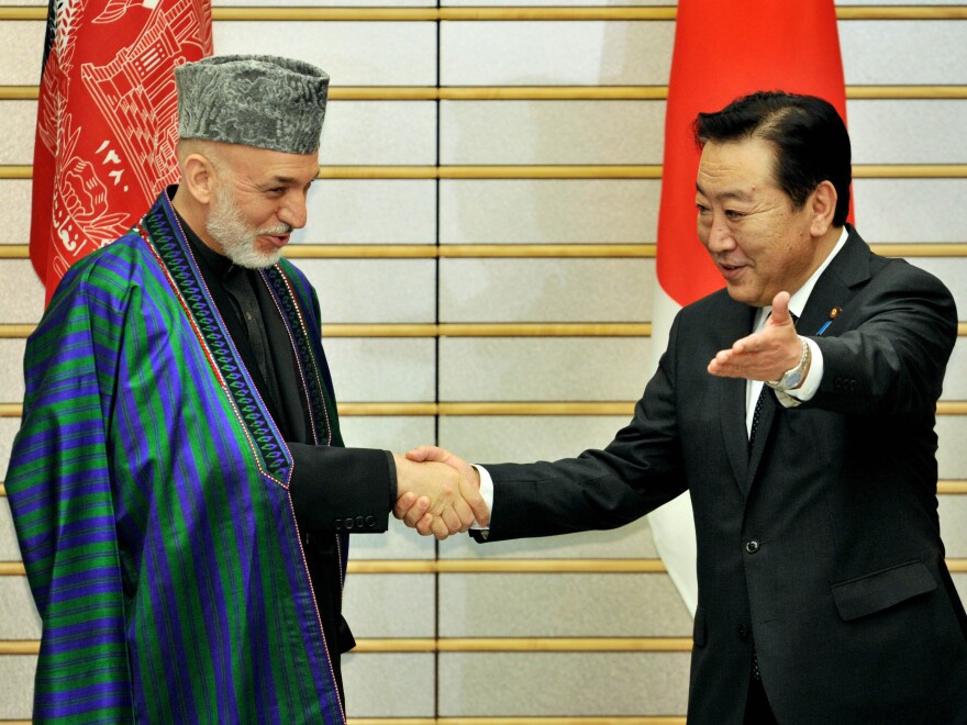 Afghan President Hamid Karzai is greeted by Japanese Prime Minister Yoshihiko Noda in Tokyo on July 9. The international community recently pledged $16 billion in additional aid, but wants Karzai to crack down on rampant corruption.