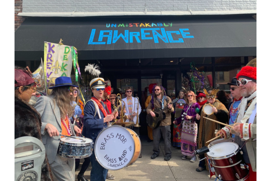 The Brass Mob Brass Band performs outside the Unmistakably Lawrence storefront.