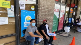 Juan Lopez and Miguel Ramirez wait 15 minutes after getting vaccinated in San Jose Market during an event from Mecklenburg Country Public Health.