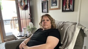 Volunteer firefighter Peg Dugan sits in her home across the street from the Tiltonsville Volunteer Fire Department. Her husband, Doug Dugan, was the chief of the department before he died on duty in 2021.