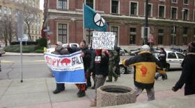 Occupy Buffalo members march outside Buffalo City Court shortly after the arraignment of ten members. They agreed to a deal in which charges will be dropped in six months if they do not camp within three miles of Niagara Square and stay out of trouble.