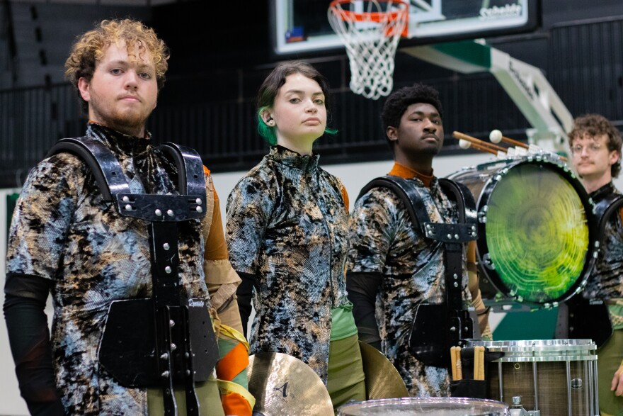 Four Resistance Indoor Percussion members stand in uniform at the group's last home rehearsal at Catoosa High School.