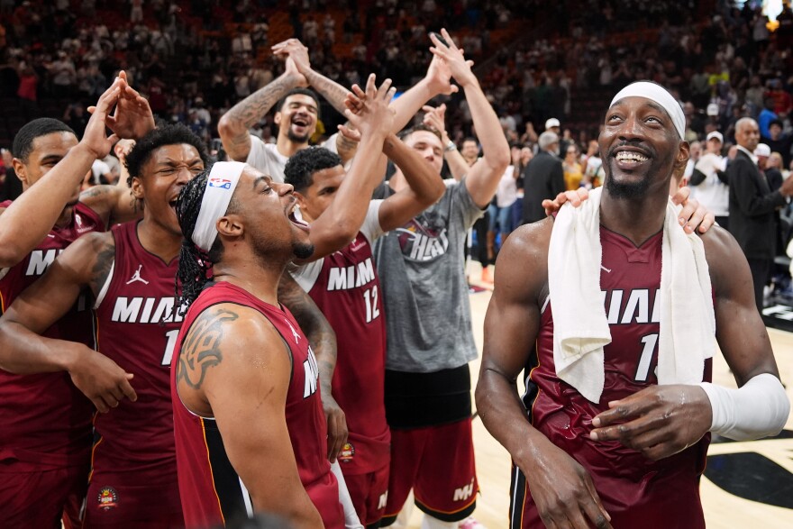 Miami Heat center Bam Adebayo, right, celebrates with teammates after he scored 83 points