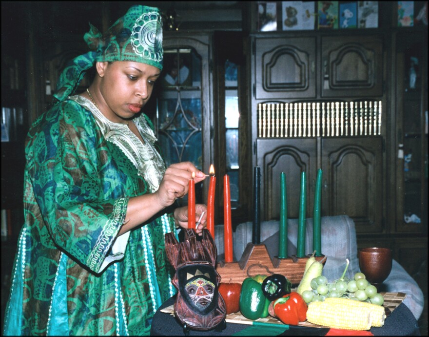 Tech. Sgt. Jennifer Myers (above), 66th Air Base Wing noncommissioned officer in charge of the Military Equal Opportunity office, demonstrates a Kwanzaa ritual where she lights a candle in the Kinara.