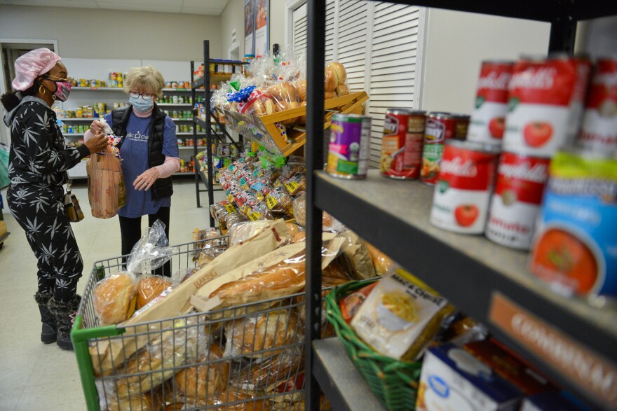 Hope Distribution Center volunteer Bridget Overman, right, helps Shonda Gooley shop for her Thanksgiving meal in Kansas City, Kansas, in 2021.