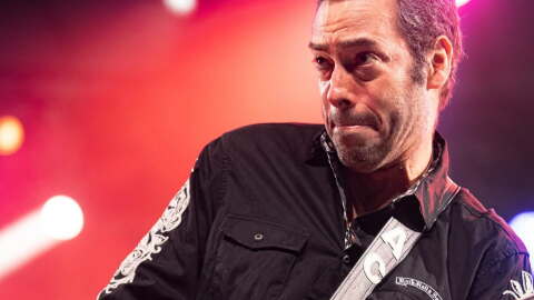 Man plays guitar on stage.