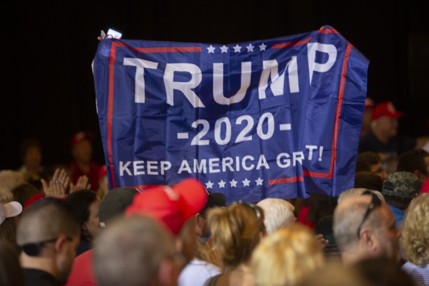 Holding a Trump 2020 banner aloft