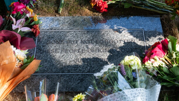 A headstone surrounded by flowers.
