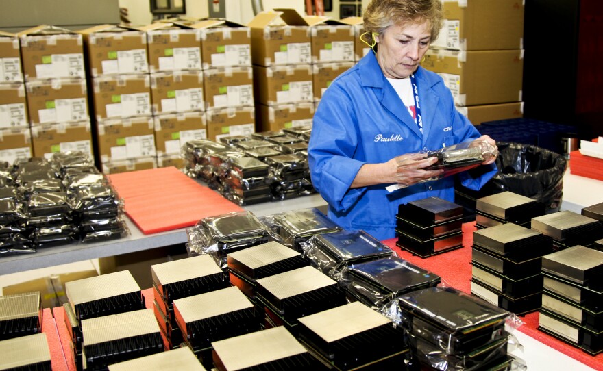 A Cray employee organizes the processors used to build Titan. To accelerate its processing power and conserve energy, Titan uses GPUs — graphics processing units. These chips were originally developed for the video game industry.