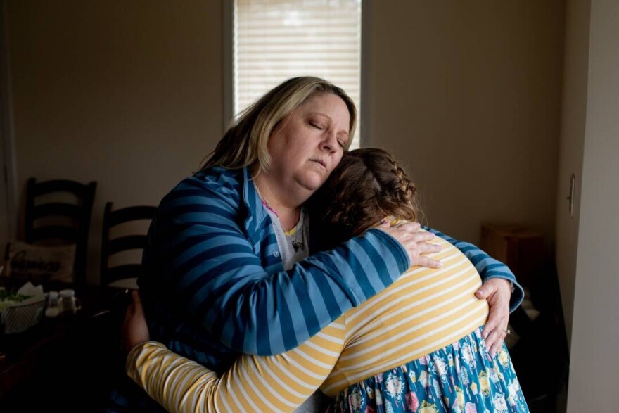Amy Cupp hugs her daughter, G, for a portrait in her home in northern Indiana. G is 12 and has multiple disabilities. Cupp has filed a federal complaint over G's treatment in school but says the process stalled after President Trump's cuts to the U.S. Education Department.