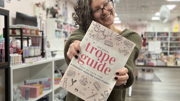 Megan Gallt holds a copy of The Novel Trope Guide, a 60-page catalog of romance books. Gallt's bookstore, Novel Grounds in Chesapeake, published the guide, which has reached nearly 15,000 readers worldwide since it was released in November 2025.