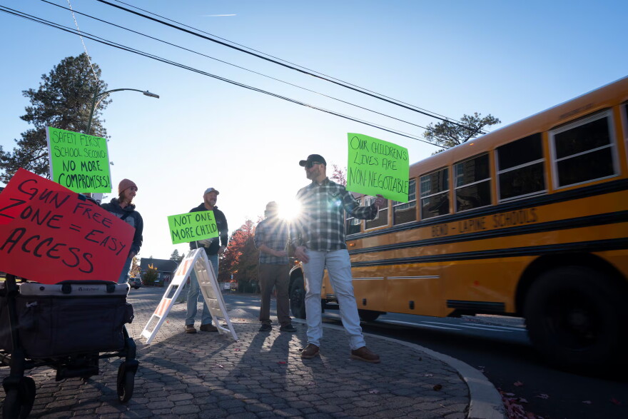 A school bus drives past as people protest outside the Bend-La Pine Schools Education Center on Oct. 23, 2026, in Bend, Ore.