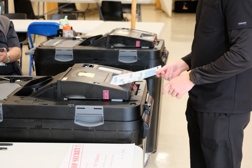 A voter enters their ballot into a counting machine during the state primary election Sept. 8, 2026 at Oyster River High School in Durham, NH.