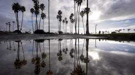 Two people walk along Mission Bay during a break in the rain in San Diego. California's current rainy season got off to a slow start but has rebounded with recent storms. (Gregory Bull/AP)