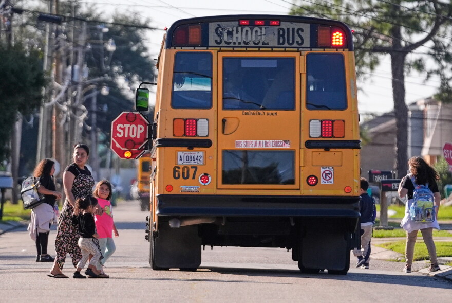 Children disembark from a school bus.