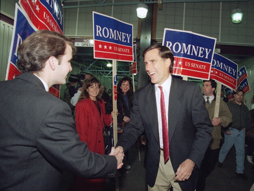 Then a Republican candidate for the U.S. Senate, Mitt Romney shakes the hand of a commuter while campaigning at North Station in Boston on Nov. 7, 1994.