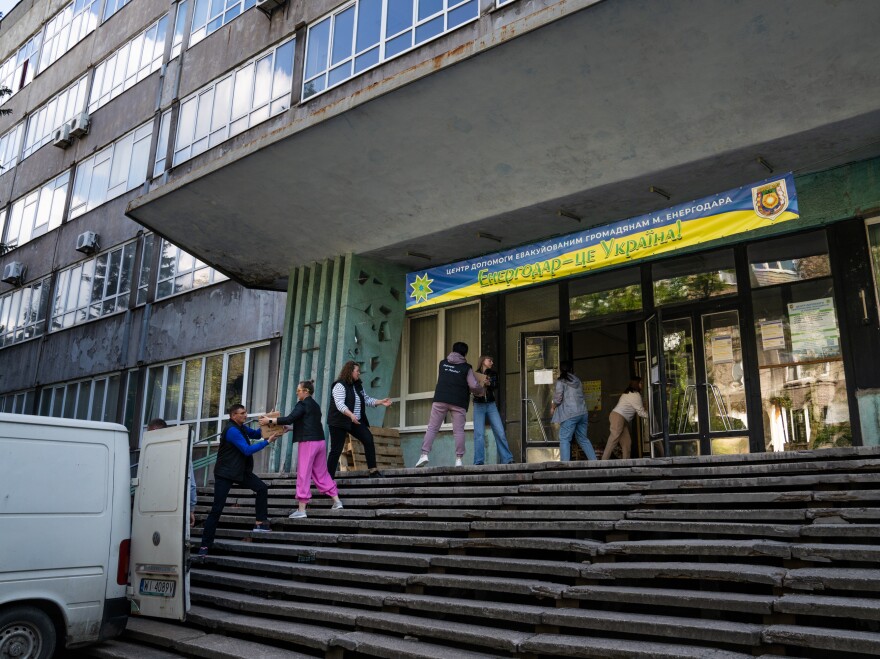 People at community center in Zaporizhzhia pack a truck with boxes of humanitarian aid to deliver to some of Enerhodar's displaced population in the area.