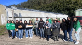 The Farmworker Outreach team, volunteers from a high school and farmworkers take a picture together at Propagation farms. 