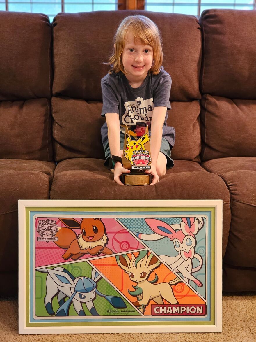  Avery Vehlewald, a 7-year-old from Overland Park, poses with his trophy and plaque that he won at the Pokémon North American International Championships.